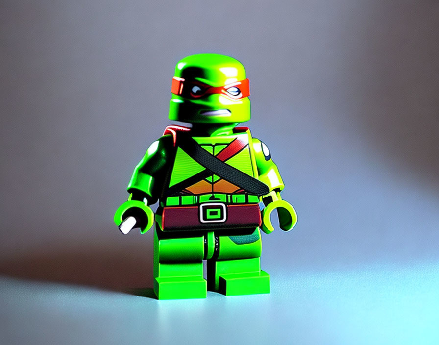Green Lego Ninja Turtle Figurine with Red Bandana and Brown Belt on Gray Background
