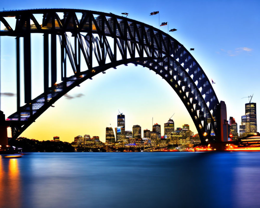 Twilight view of Sydney Harbour Bridge and city skyline lights reflected on water