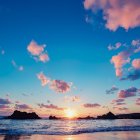 Vibrant sunset with clouds and bubbles above serene ocean