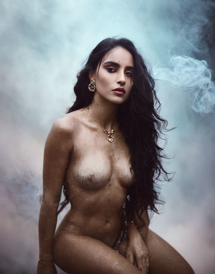Dark-haired woman adorned with jewelry in captivating pose amid swirling mist