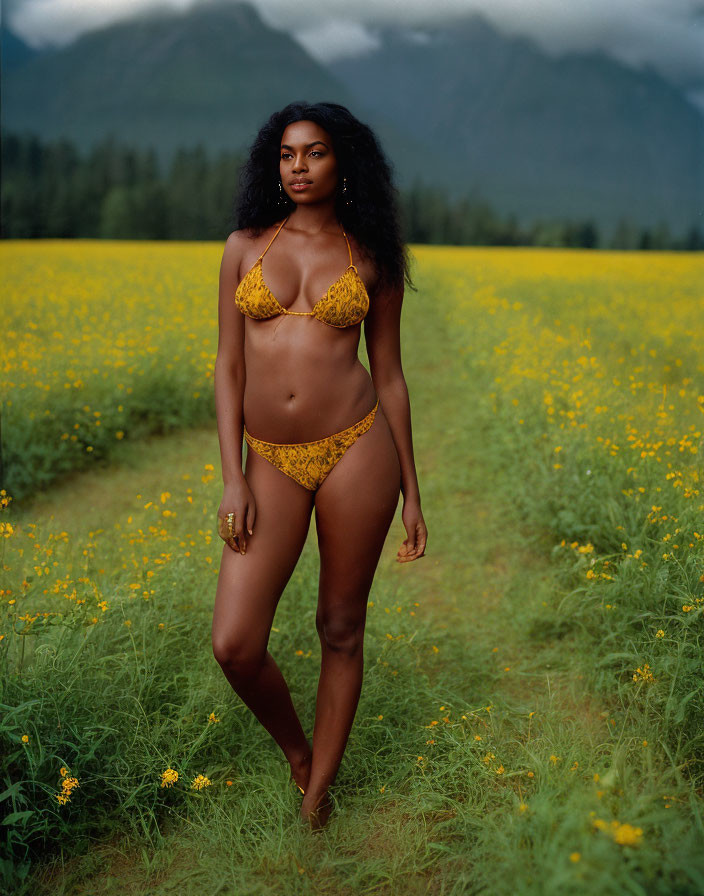 Woman in Yellow Bikini in Vibrant Flower Field with Mountains