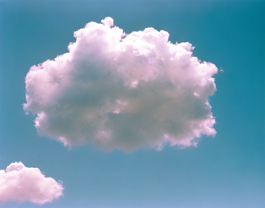 Fluffy white cloud in pale blue to pinkish-purple sky