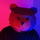 Plush bear under vibrant purple and red lights