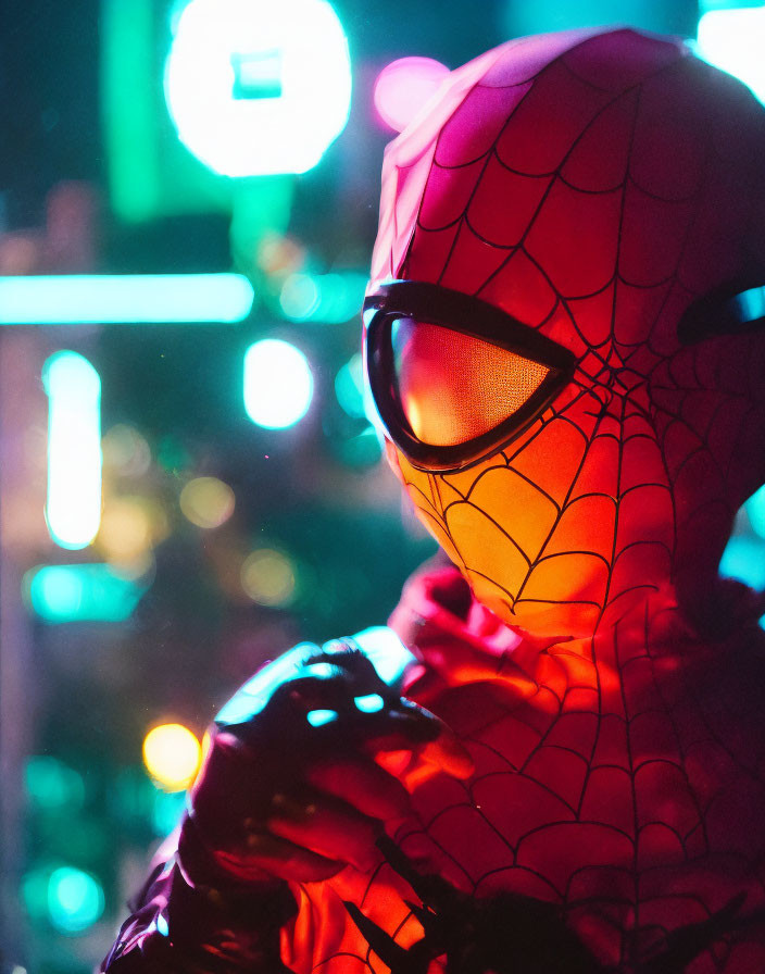 Person in Spider-Man costume with illuminated signs at night