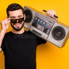 Digital artwork: Woman with blue and purple hair holding retro boombox on vibrant orange background