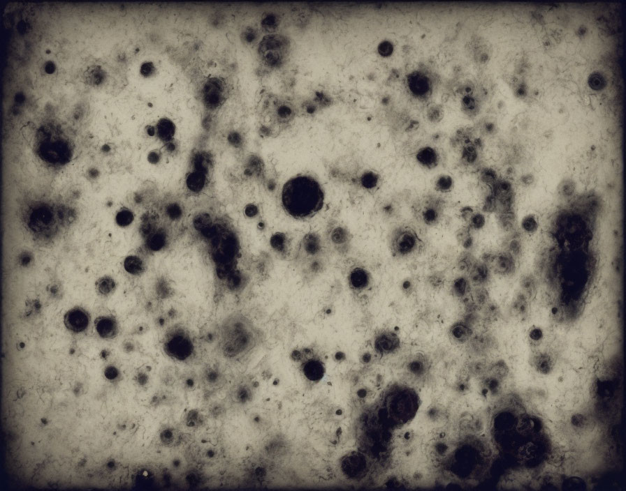 Abstract dark circular blotches on textured gray background