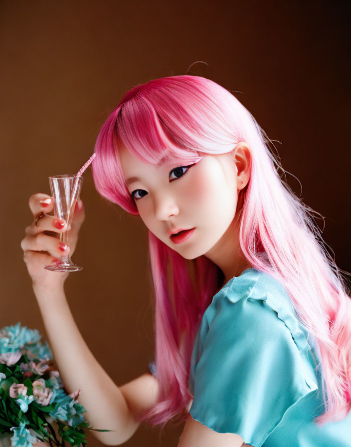 Pink-haired woman with champagne glass and flowers on brown background