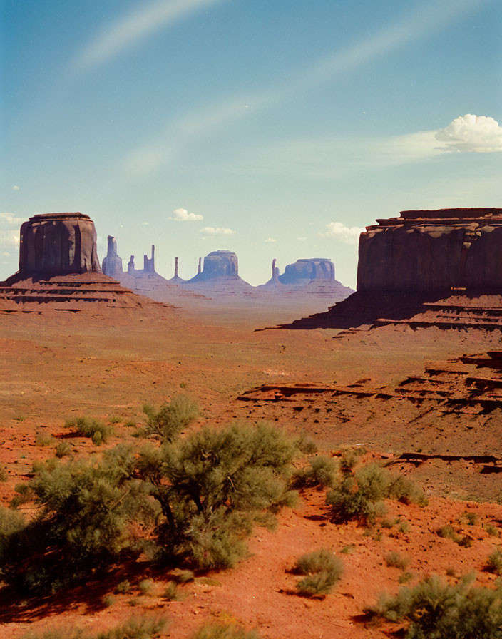 Majestic red desert landscape with towering rock formations under a blue sky