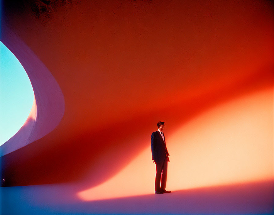 Surreal red and blue space with lone figure and dramatic lighting