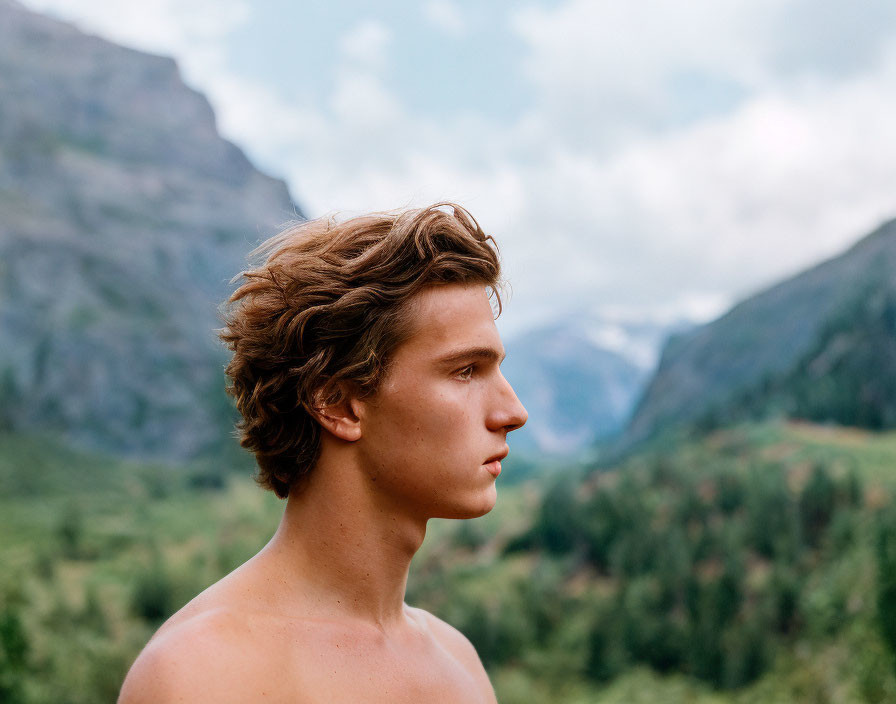 Curly-Haired Young Man Contemplating Mountains and Valley