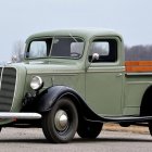 Vintage Green Truck with Dual Headlights and Orange Stripe in Gray Landscape