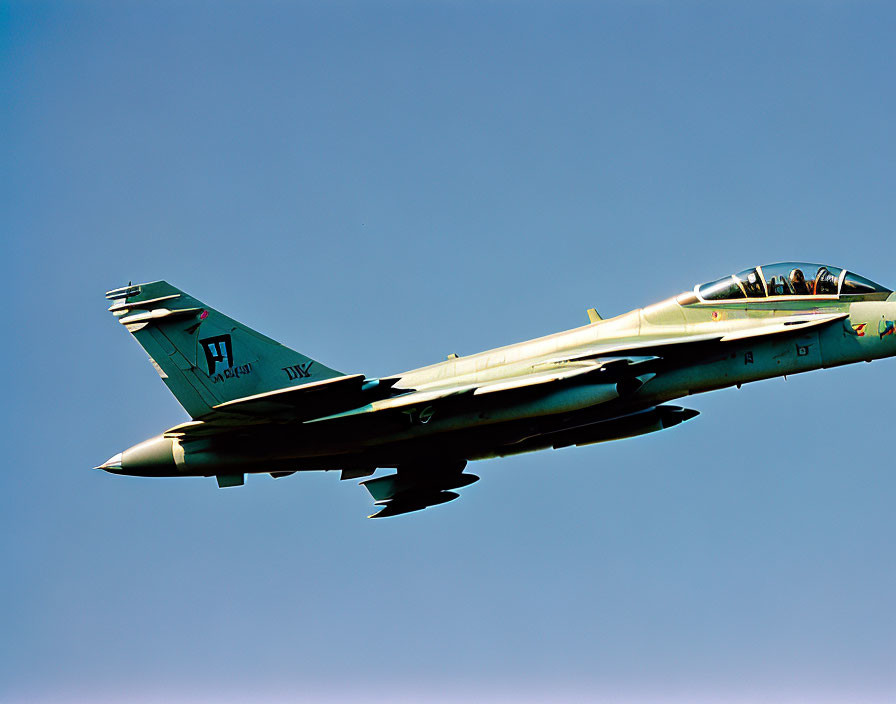 Camouflaged fighter jet with "PAF" crest in flight against blue sky