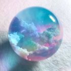 Vibrant colors reflected in crystal ball on pastel background