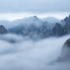 Majestic misty mountain landscape with towering peaks in dense fog