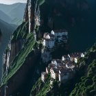 Fantastical village with traditional houses and pagodas on lush green cliffs