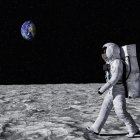Astronaut in white spacesuit walking on moon's surface with Earth in background
