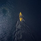 Yellow Kayak Over Dark Coral Reef in Clear Blue Water