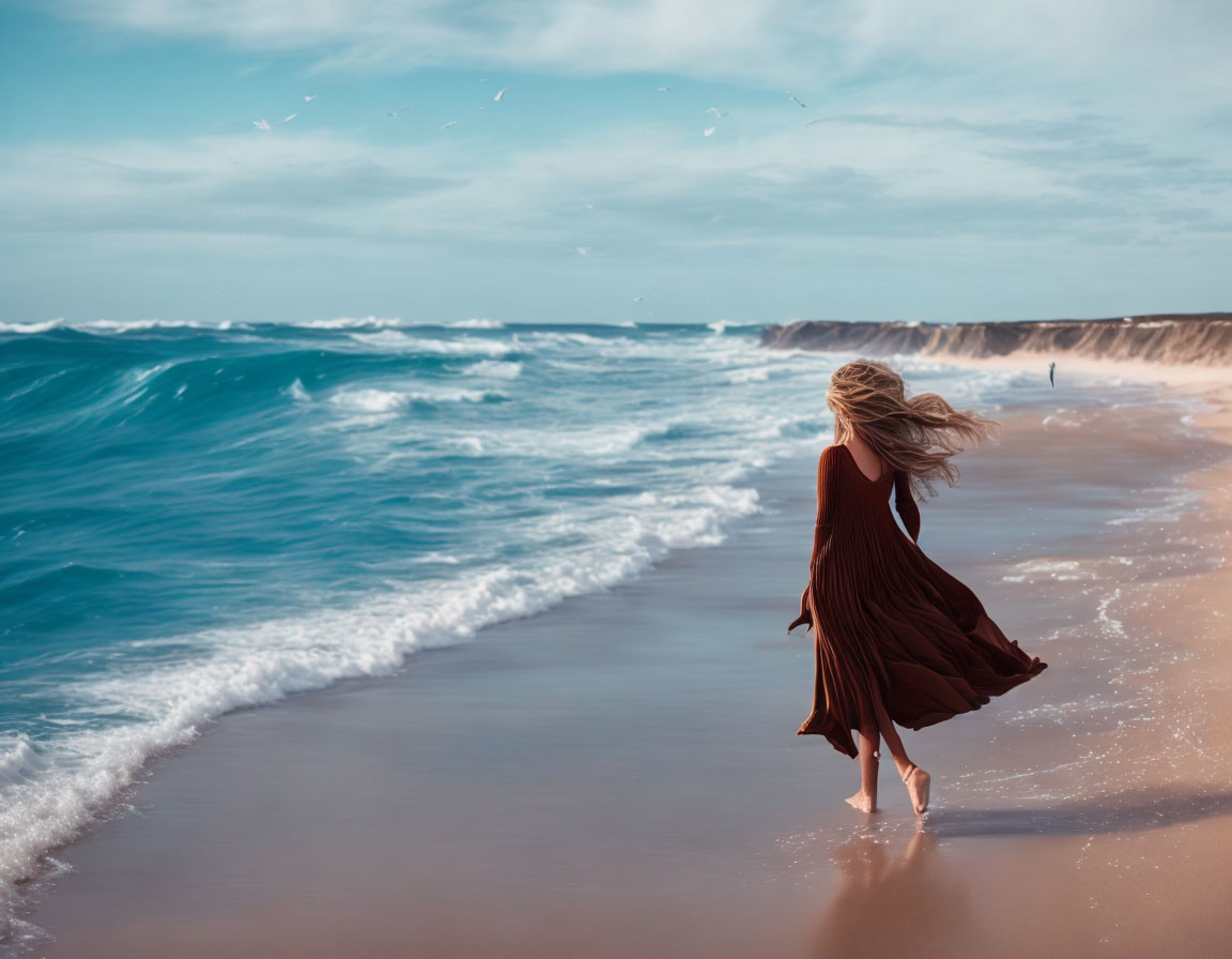 Woman in flowing brown dress walking on beach with crashing waves and flying seagulls