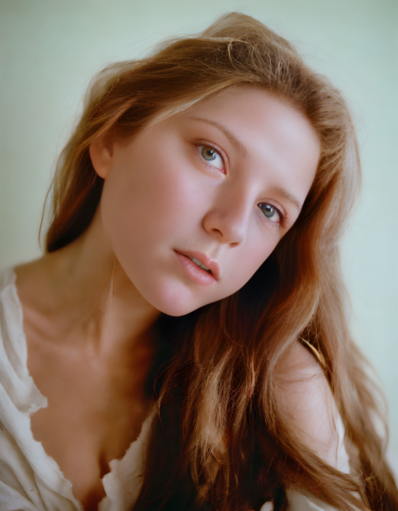 Young Woman with Long Brown Hair and White Shirt on Soft-Colored Background