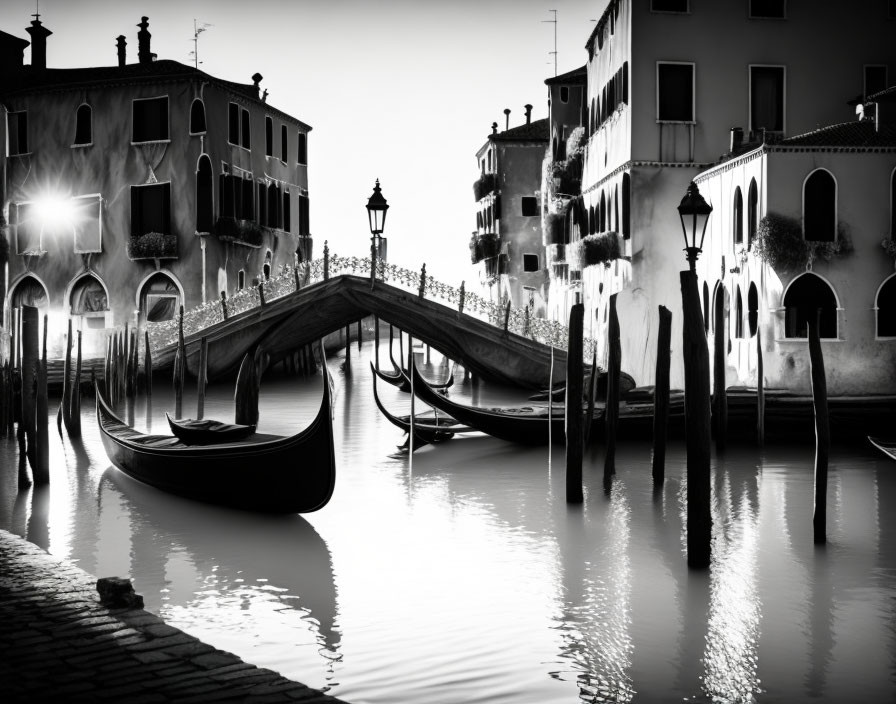 Monochrome photo: Venetian canals, gondolas, old buildings, glowing street lights