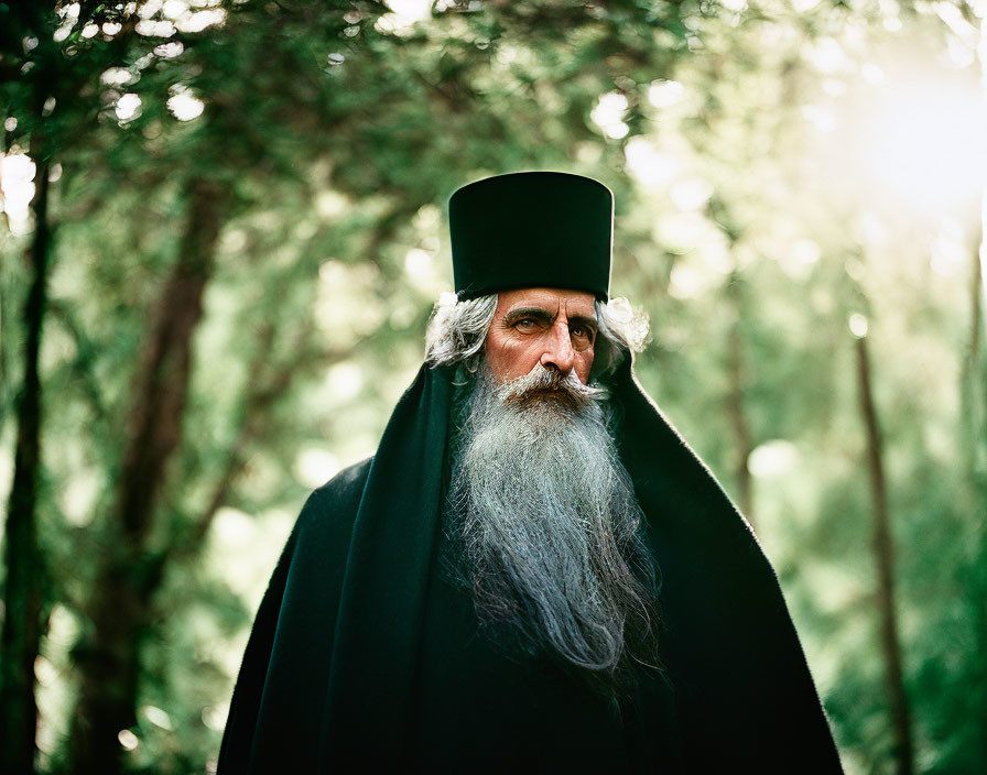 Elderly Bearded Man in Religious Attire Contemplating in Sunlit Forest