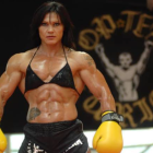 Muscular Female Bodybuilder in Bikini and Boxing Gloves with Trophy