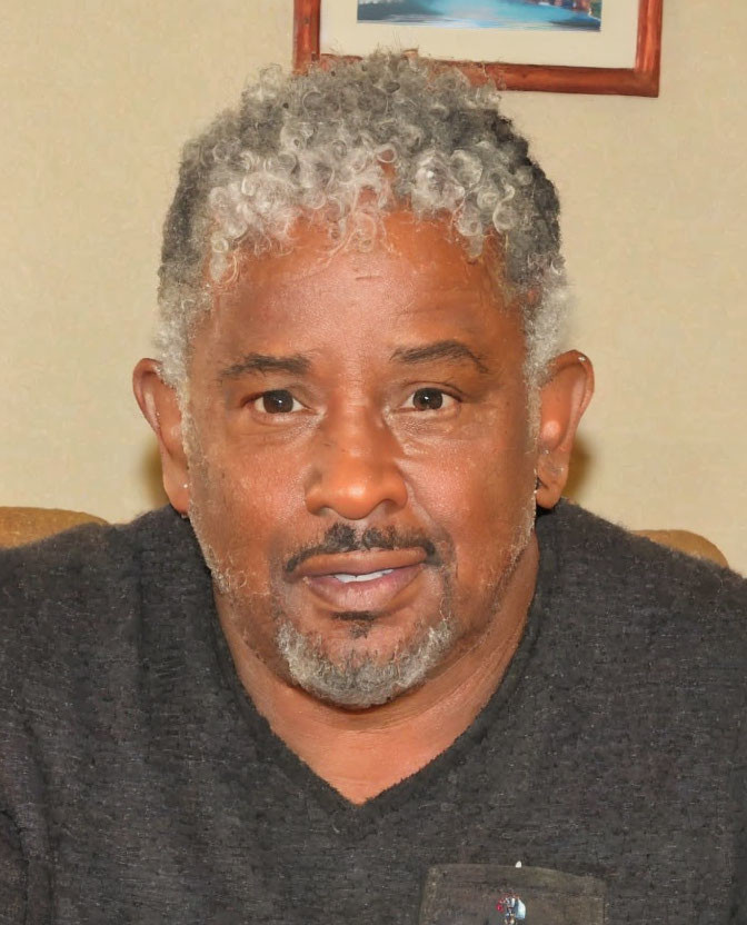 Gray-Haired Man with Goatee Smiling in Black Sweater Indoors