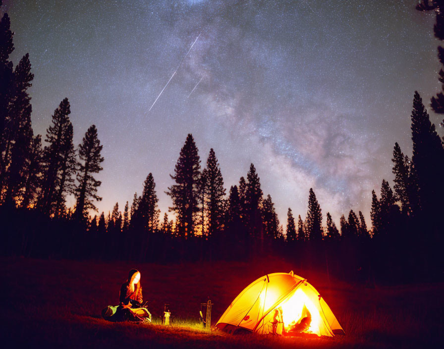 Person sitting near glowing tent under starry sky in serene forest at night