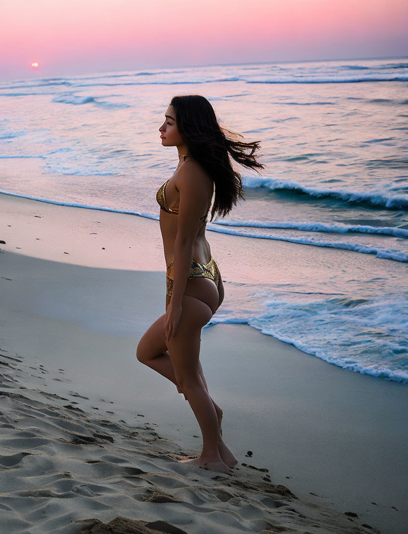 Person in Gold Bikini on Sandy Beach at Sunset with Pink Sky