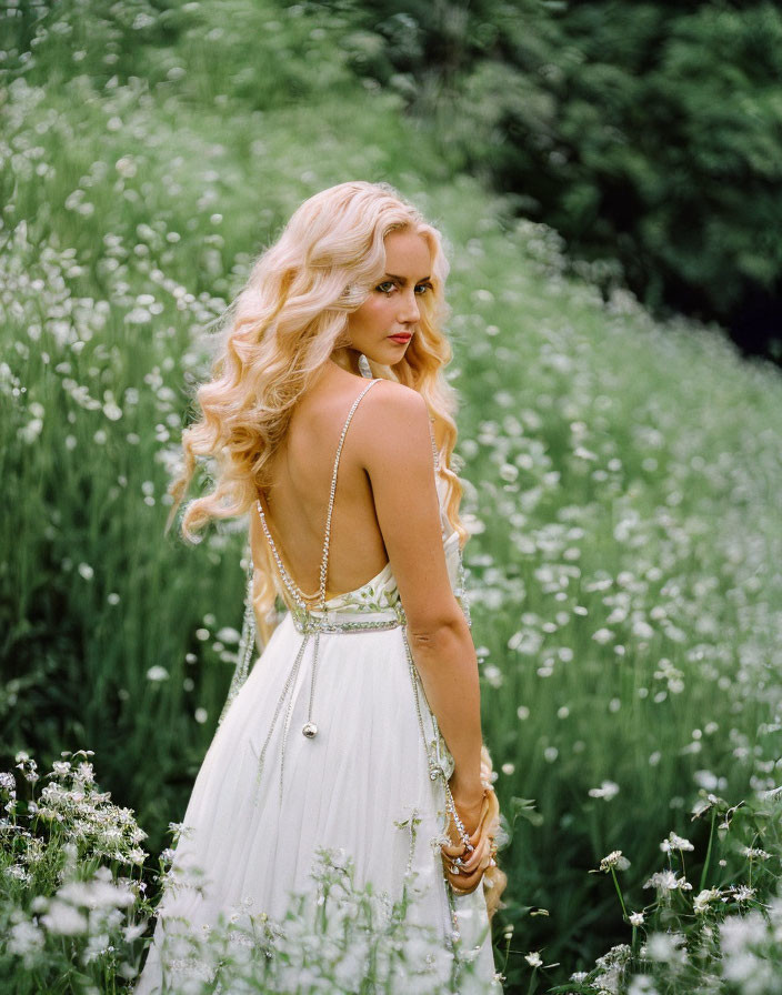 Blonde woman in white dress in field of white flowers