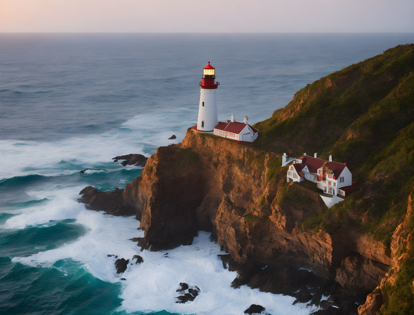 Rugged cliffs lighthouse with red roofed building by stormy sea