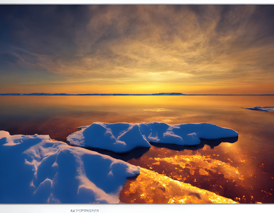 Tranquil snow-covered rocks by golden sunset and cloudy sky