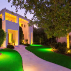 Luxurious villa at dusk with illuminated garden paths and stylized lighting.