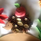 Colorful Stylized Hedgehog Surrounded by Paper-Like Flowers
