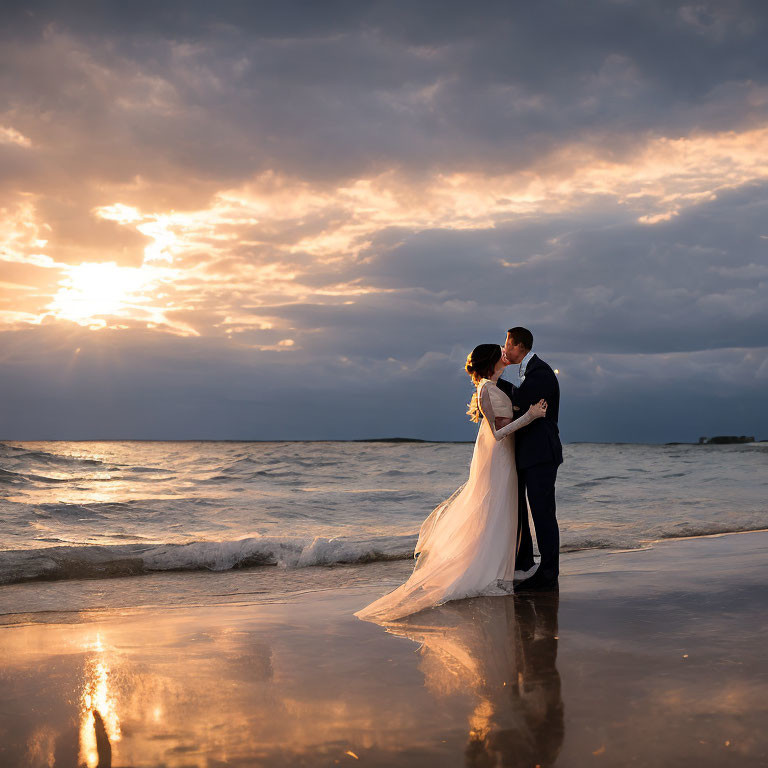 Wedding couple embracing on beach at sunset