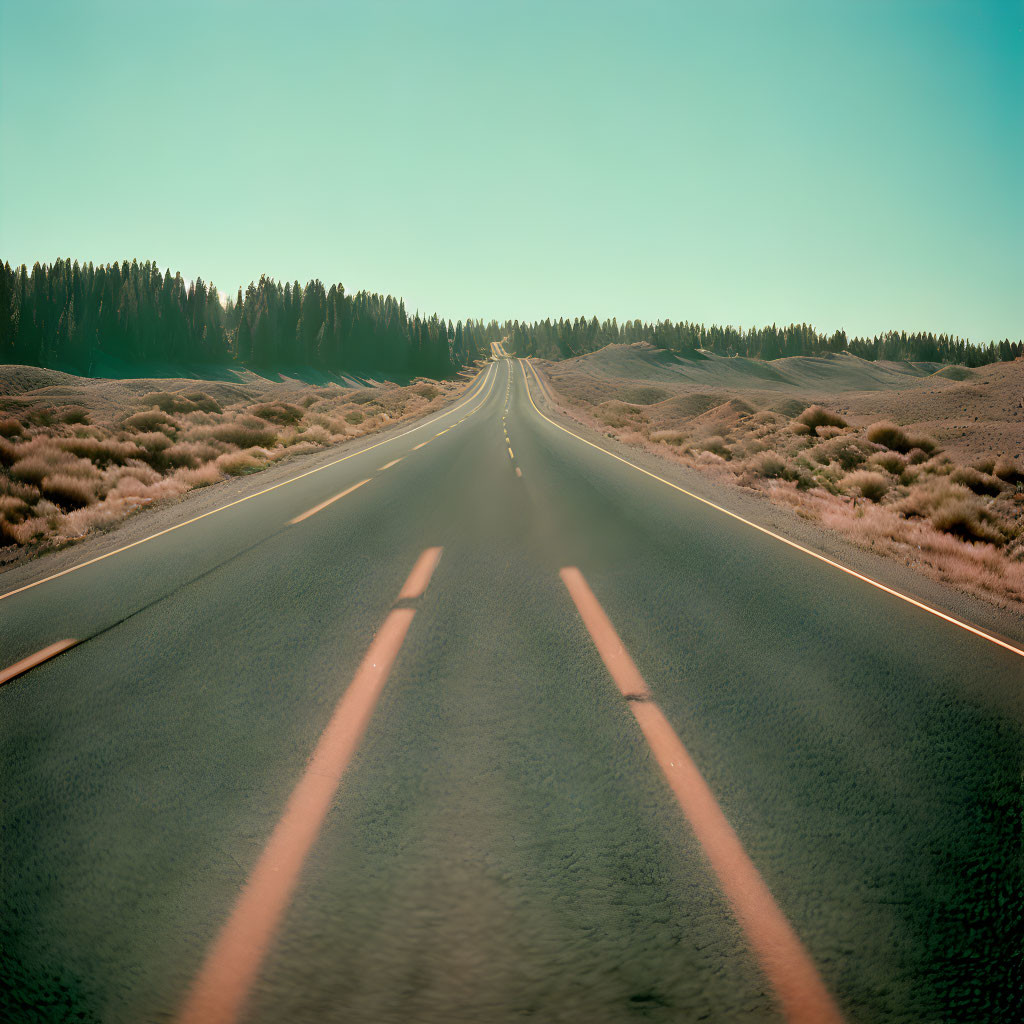 Deserted highway in arid landscape under clear sky