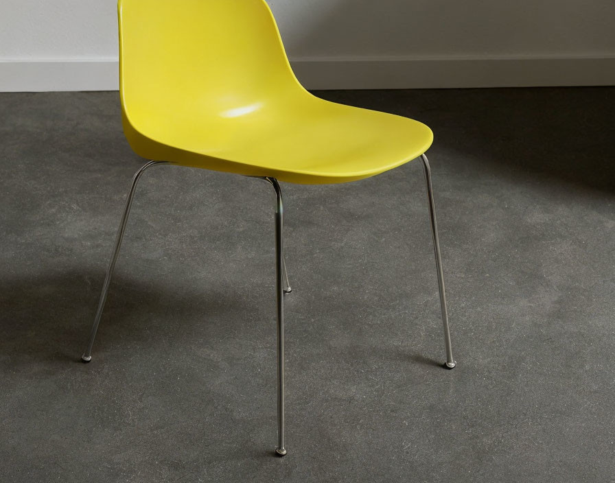 Yellow Modern Chair with Curved Seat and Silver Metal Legs on Gray Textured Floor