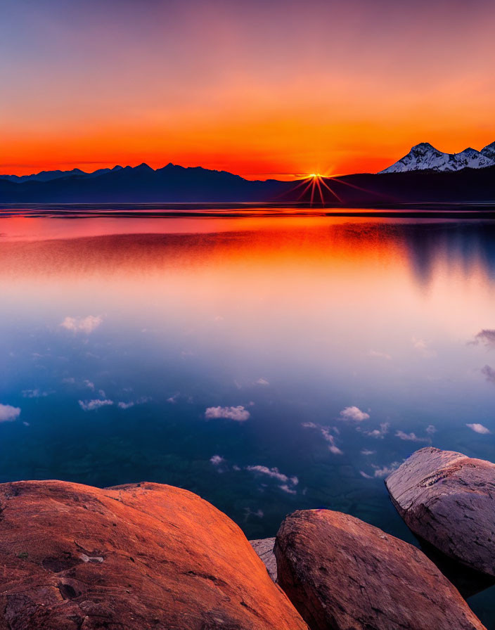 Scenic sunset over calm lake with mountain silhouette