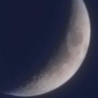 Detailed Close-Up: Waning Crescent Moon in Starlit Sky