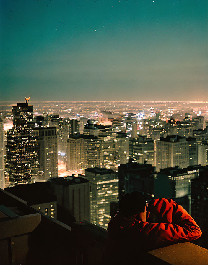 Person in Red Jacket Overlooking Night Cityscape with Stars
