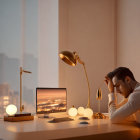 Man at desk with computer under lamp, cityscape view at dusk