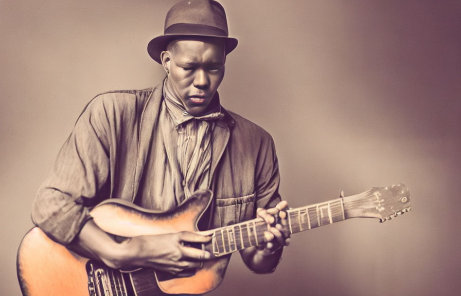 Man in fedora playing electric guitar against sepia background
