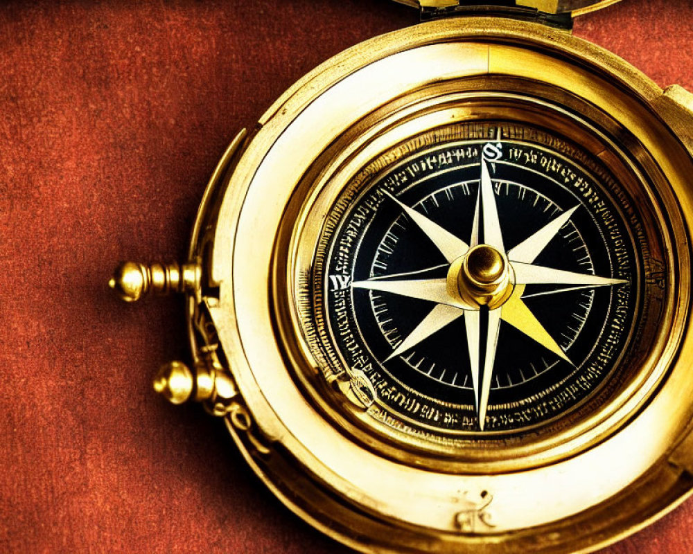 Vintage Brass Compass on Maroon Textured Background