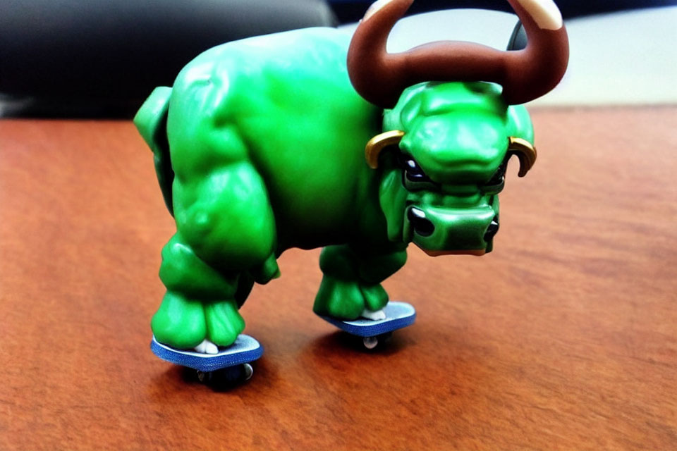 Green Bull Toy Figure on Mini Skateboards on Desk Surface