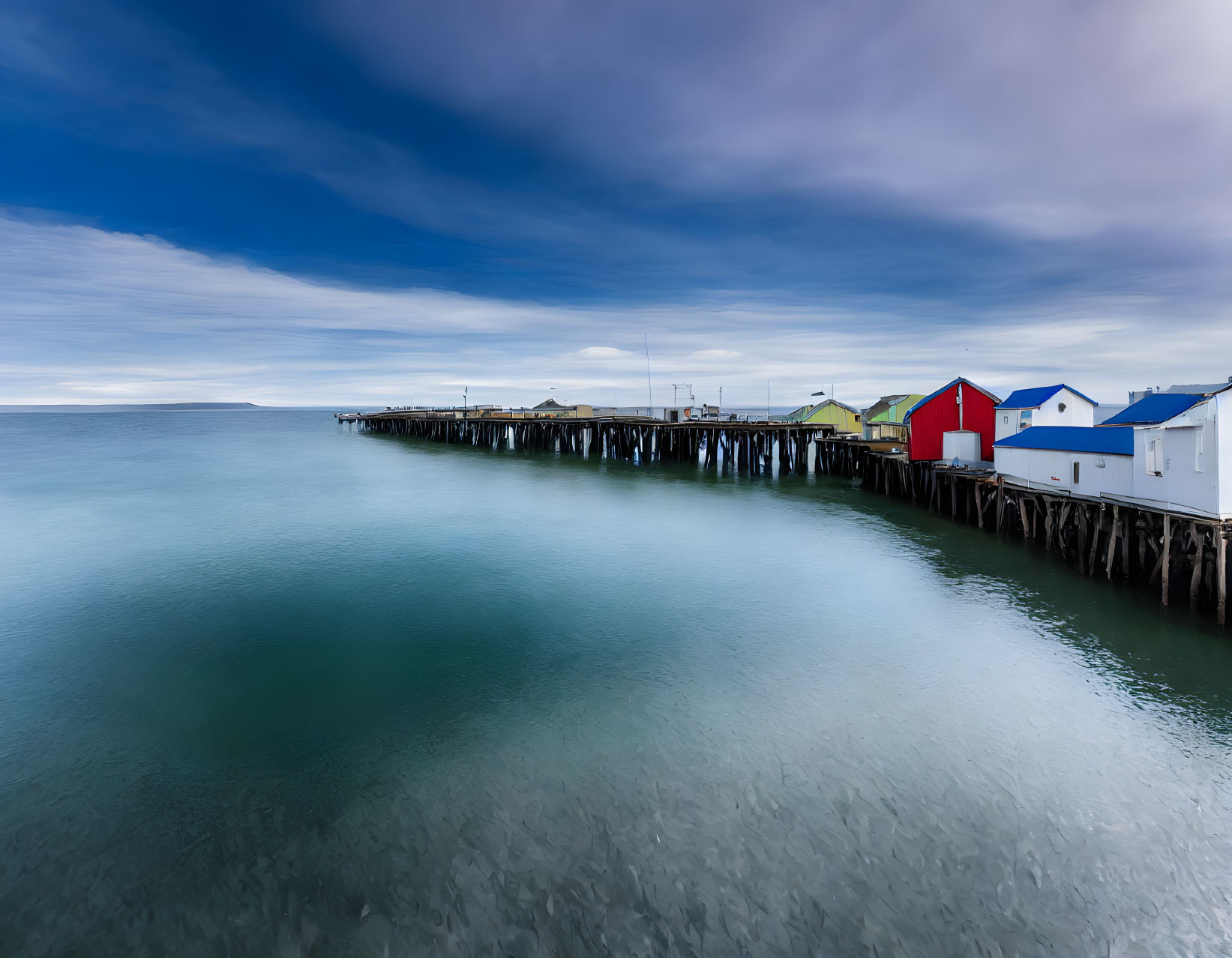 Colorful houses on wooden pier in serene seascape