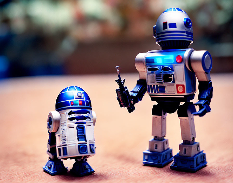 Two R2-D2 Toy Figures on Wooden Surface