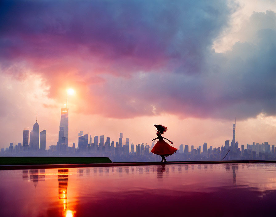 Silhouette of person twirling in dress against cityscape and colorful sunset