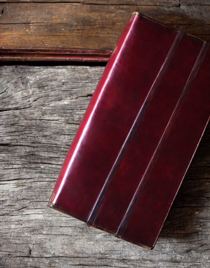Burgundy Leather-Bound Book on Wooden Surface