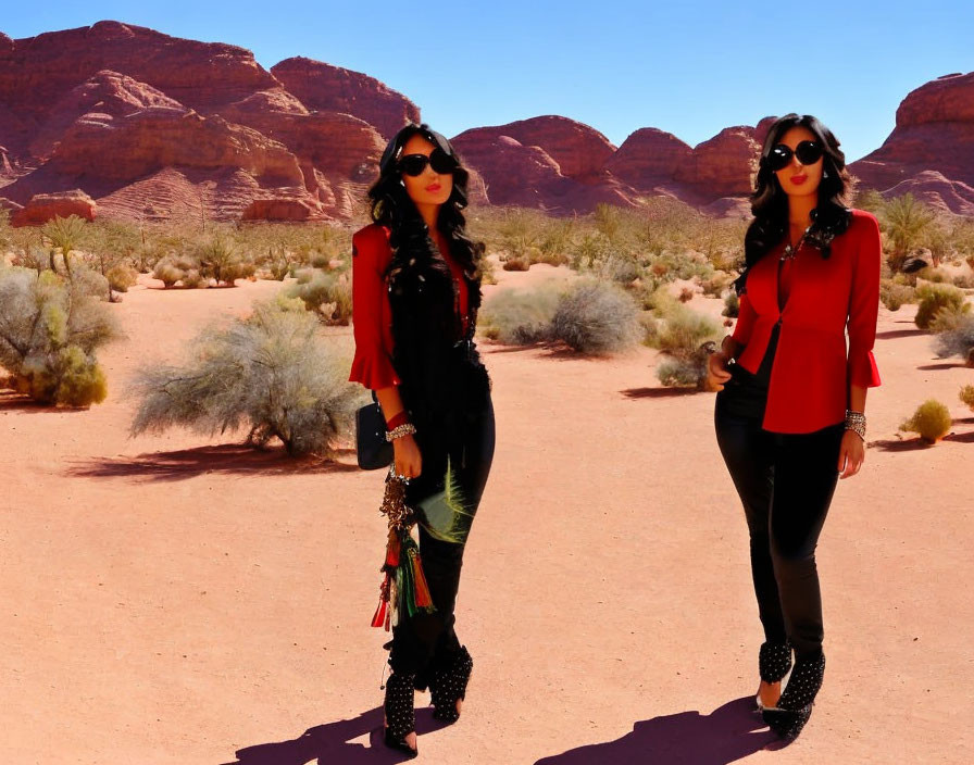 Fashionable women in sunglasses posing in desert with red rock formations.