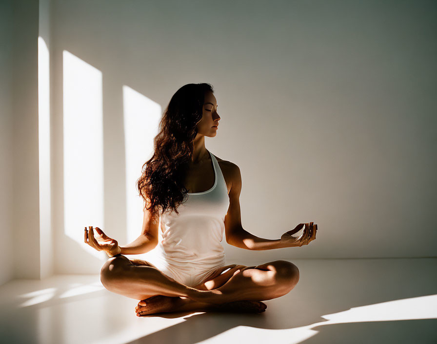 Woman in White Outfit in Serene Yoga Pose with Natural Light
